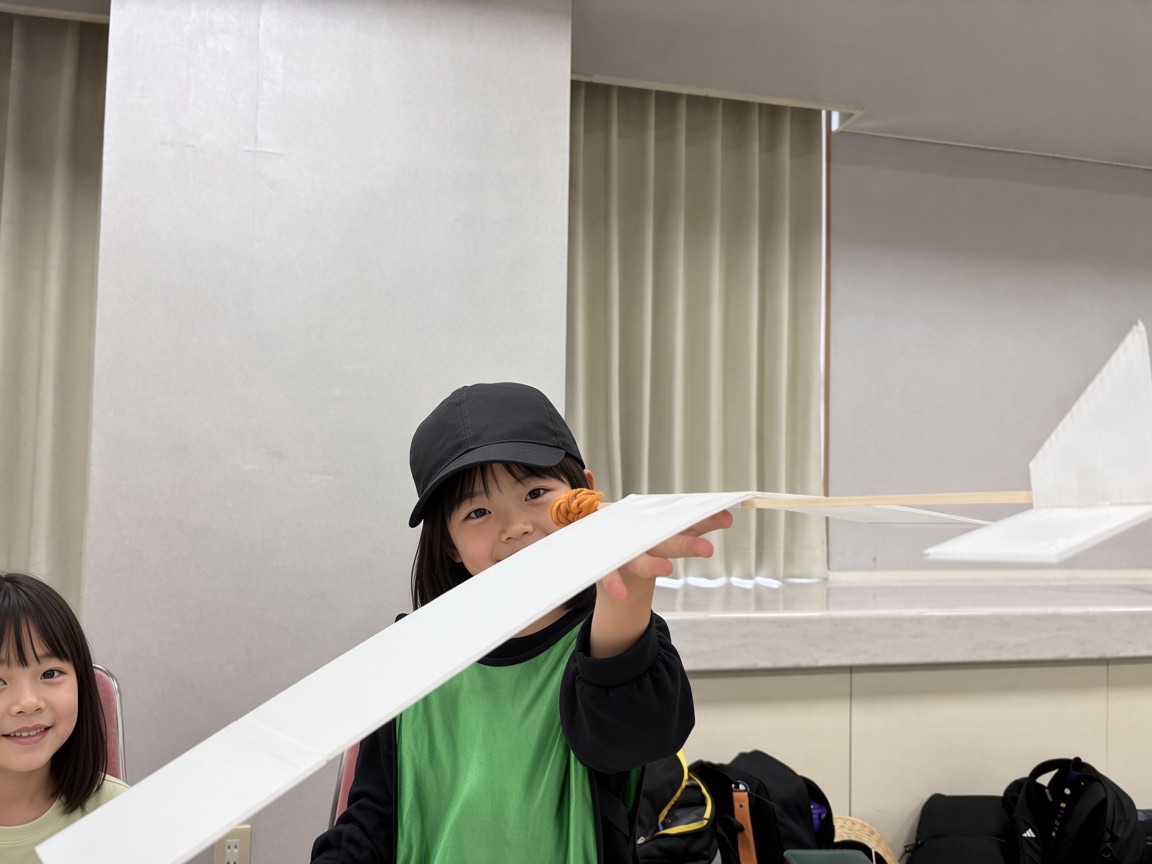 白い翼の大型飛行機を両手で支える子ども