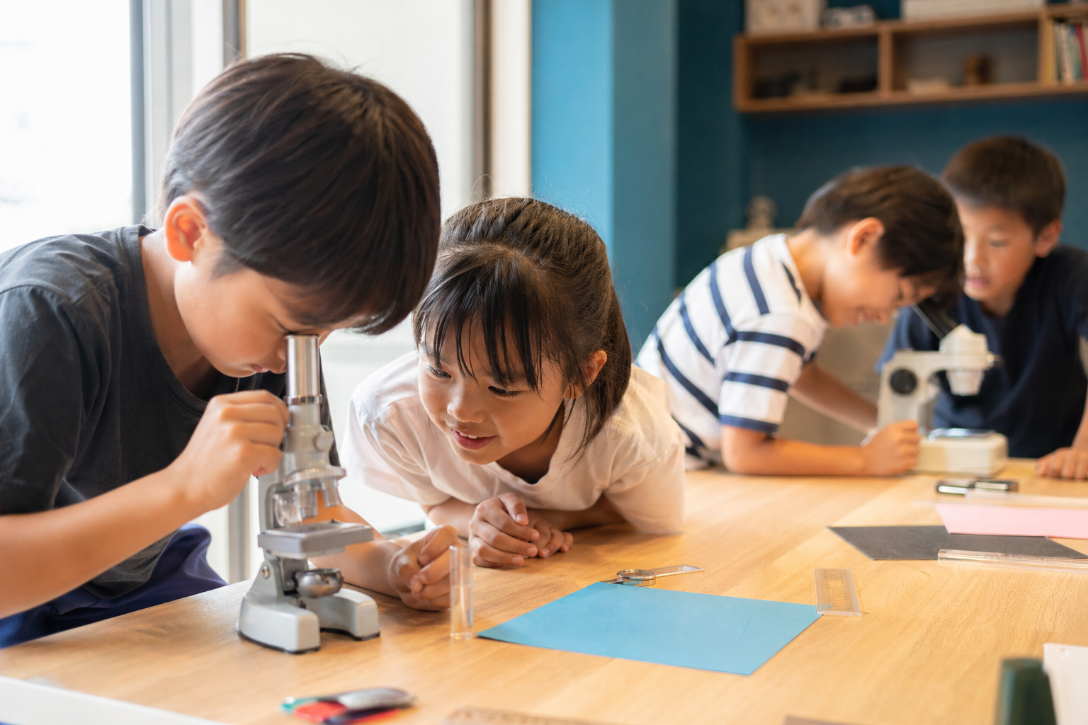 顕微鏡で紙やすりを観察する子どもたち